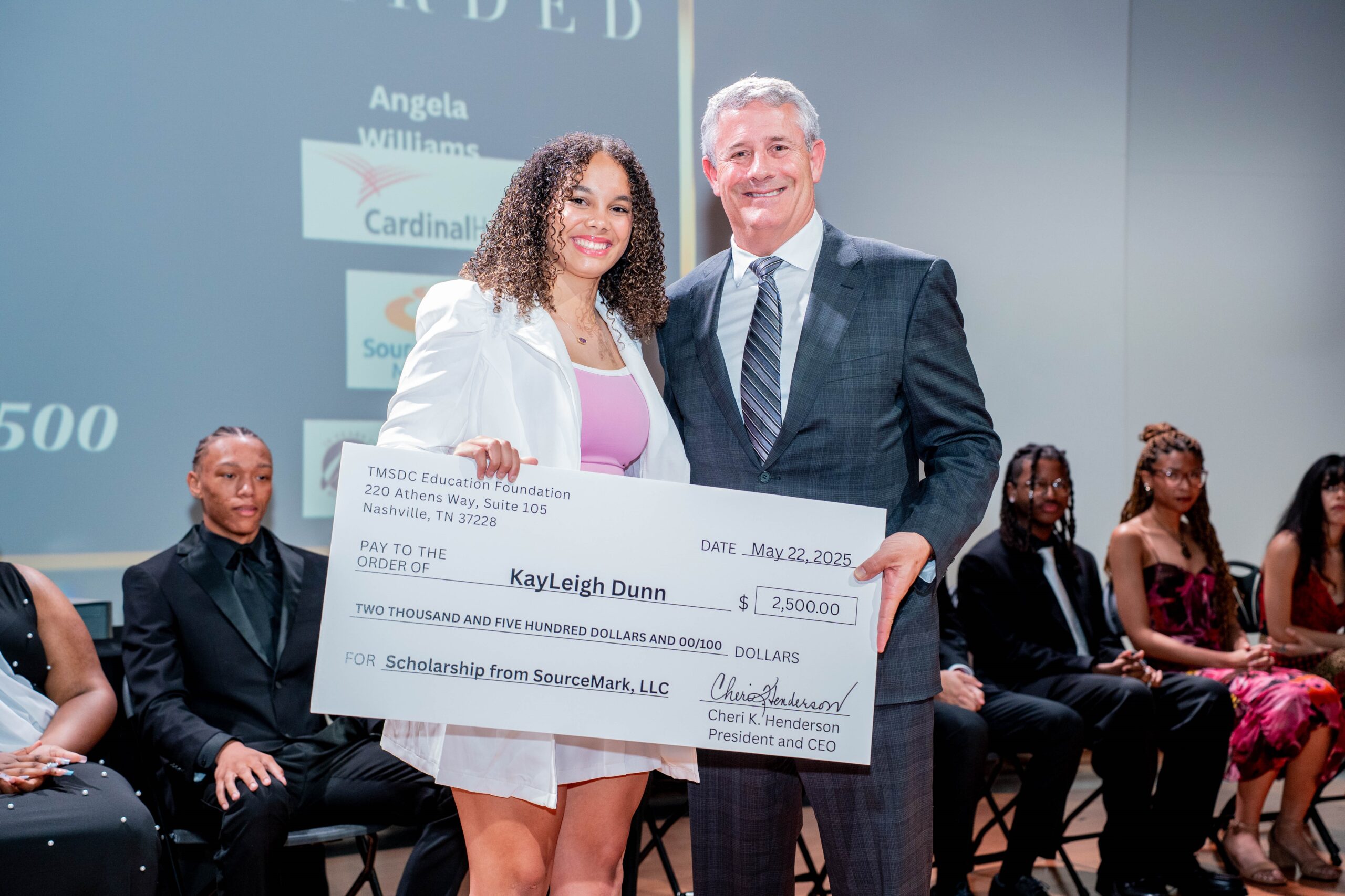 SourceMark CEO, Daniel Blucher, presenting a $2,500 scholarship to KayLeigh Dunn.